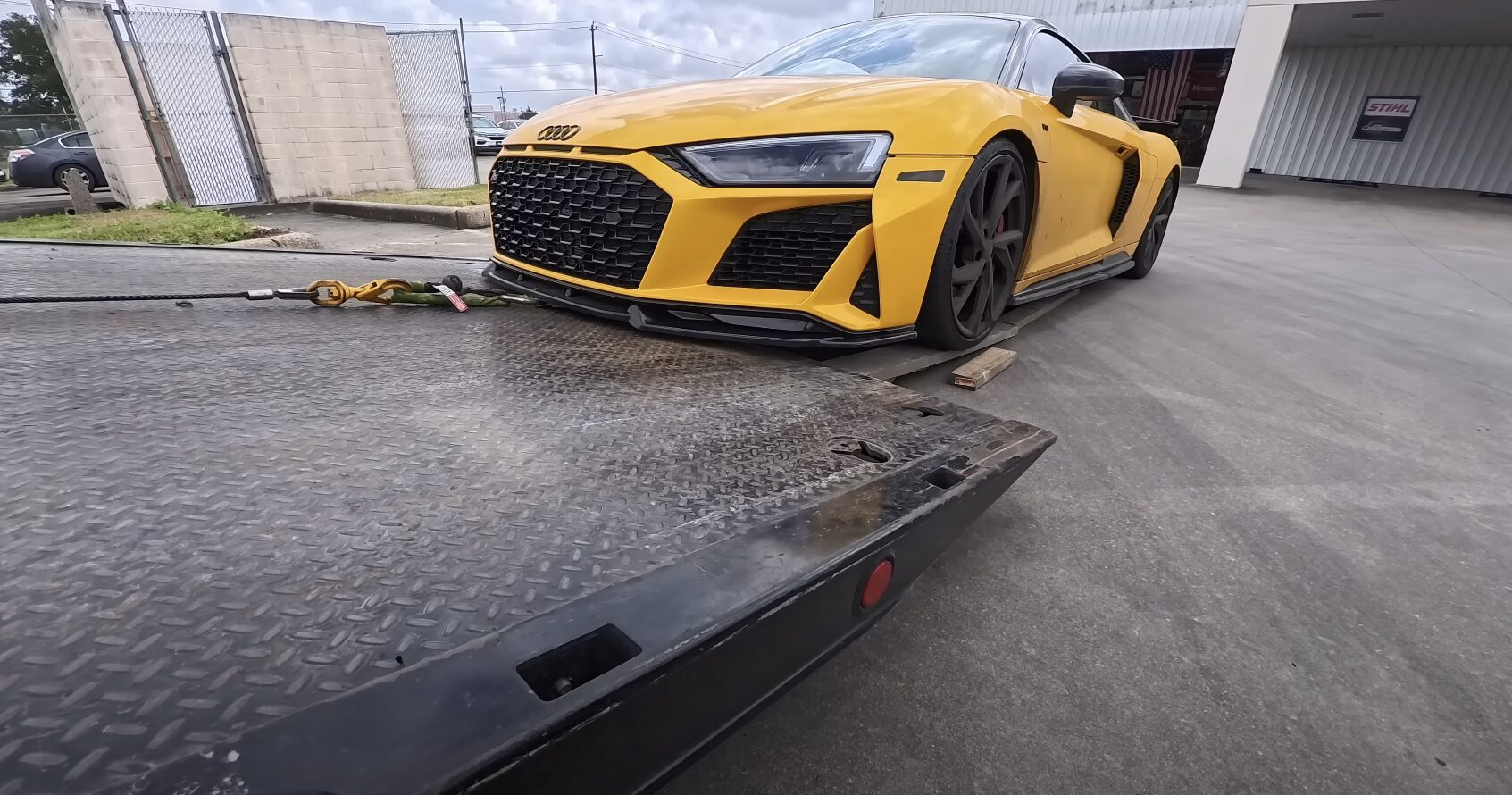 High-end sports car being loaded onto professional flatbed tow truck